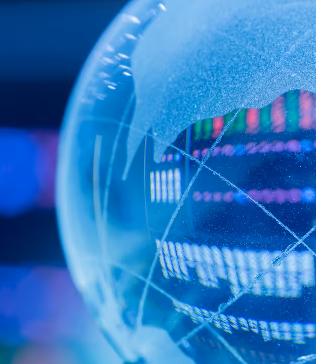Close-up of a transparent globe with digital data charts and colorful stock market graphs in the background